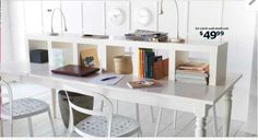 a white table with some books on top of it and two chairs next to it