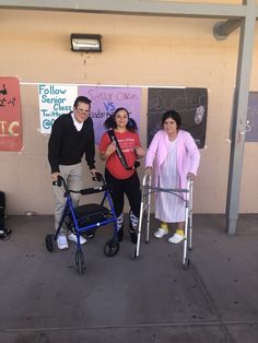 three people standing next to each other in front of a wall with signs on it