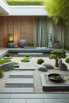 a garden with rocks, grass and plants in the middle of it is surrounded by bamboo trees