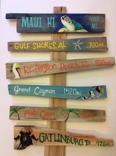 a wooden sign with many different types of signs on it's sides and the words, gulf shores al, reunion beach fl, grand cayann,