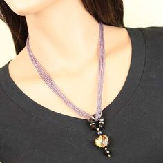 This gorgeous contemporary Murano necklace in rich amethyst and gold color palette features an exquisite 24K gold-layered heart at the center attached to a beautiful beaded ring and suspended from an elegant multi-strand beaded necklace. When this Venetian necklace captures the light you can really see it shine, as the seed beads and the heart light up with rich shades of amethyst, violet, and lilac reminding us of the treasures kept in Venice's decadent palazzos. This Murano glass necklace is a Elegant Round Glass Crystal Necklaces, Elegant Beaded Necklaces With Unique Variations For Gift, Elegant Glass Crystal Necklaces For Party, Elegant Beaded Necklace With Round Beads, Elegant Silver Glass Crystal Necklace, Elegant Czech Glass Crystal Necklace With Round Beads, Elegant Party Jewelry In Czech Glass, Elegant Purple Round Beaded Necklaces, Elegant Purple Necklace For Celebration