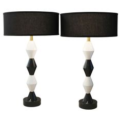 two black and white lamps with shades on them