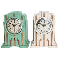 two clocks sitting side by side on top of each other, one green and the other white