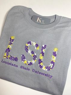 Custom University Embroidered Floral Tee. This unique shirt features delicate embroidered flowers on the letter initials of the college of your choice, adding a feminine touch to your fan gear. Gildan College Shirt Design Ideas, Embroidered Short Sleeve College T-shirt, College Embroidered Short Sleeve T-shirt, Embroidered Short Sleeve T-shirt For College, College Shirts Design, College Shirt Diy, College Shirt Design, College Tshirts, Physical Therapy Shirts