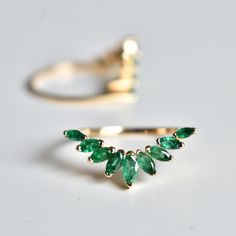 "Pop of green Emeralds in this sunburst ring enhancers are a great addition to your engagement and add sparkle, this wrap ring features marquise cut natural emeralds and is handcrafted in 14k solid gold. It adds the right amount of royal and drama to your classic solitaire engagement ring. A perfect anniversary gift! DETAILS FOR SINGLE BAND: * Gemstone : Natural Green Emeralds * Emerald Wt. : ~0.75 Ct * Gold - 14kt, ~2.5 gm solid gold If you like this ring, please press \"Pin it\" button on the Emerald Ring Leaves, Emerald Enhancer Ring, Green Emerald Engagement Ring With Band, Emerald Green Wedding Band With Engagement Ring, Green Wedding Band Women, Emerald Gold Rings, Emerald Engagement Ring Nature, Emerald Leaf Ring, Emerald Green Wedding Band