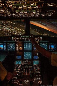 two pilots in the cockpit of an airplane at night