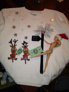 a white shirt with christmas decorations on it and a barbie doll hanging from a street light