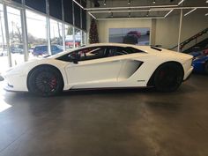 a white sports car parked in a showroom