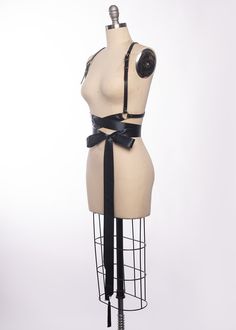 High quality, durable-yet-delicate bespoke harness made in leather or vegan leather. Embellished with tassels. Luxurious wide satin ribbons wrap around the waist and tie into a bow. Choose from gold or silver toned nickel plated steel hardware. Shown in black leather/gold ribbon/gold hardware and black leather/black ribbon/silver hardware. Custom sizing available. All pieces are MADE TO ORDER, standard sizes XS-4XL. If your measurements fall outside these standards or you are unsure of what size Adjustable Belt Harness For Party, Fitted Strapped Harness For Party, Gothic Black Harness With Straps, Black Gothic Harness With Straps, Adjustable Leather Harness With Belt, Gothic Black Harness With Adjustable Straps, Black Gothic Harness With Adjustable Straps, Adjustable Strap Harness For Party, Black Fitted Gothic Harness