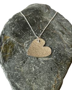 A  handmade sterling silver hammered finish heart necklace features a heart-shaped pendant that measures 30mm in size. The heart pendant is crafted from sterling silver and has a hammered finish, which adds texture and shine to the piece. The pendant is suspended from a delicate sterling silver chain that is available in two lengths: 40cm or 45cm. The chain is also made from high-quality sterling silver and has a sleek and smooth finish that complements the hammered texture of the pendant. The n Sterling Silver Hand Stamped Heart Necklace, Hammered Silver Heart Jewelry, Sterling Silver Hand Stamped Heart Pendant Necklace, Silver Heart Necklace With Hand Stamped Details, Hammered Heart-shaped Jewelry Gift, Hand Stamped Sterling Silver Heart Pendant Necklace, Stamped Sterling Silver Heart Pendant Necklace, Heart-shaped Hammered Sterling Silver Jewelry, Hand-stamped Sterling Silver Heart Pendant Necklace