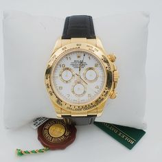 Men's Rolex 40mm Daytona 18K Yellow Gold Watch with Black Leather Strap and White Dial. Pre-Owned SN# Y94**** Brand: Rolex. Gender: Men's. Model: Daytona. Type: Wristwatch. Case Size: 40mm. Dial Color: White. Bezel Color: Gold. Condition: Excellent. Band/Strap: Leather. Indices: Non-Numeric. Band Material: Leather. Bezel Type: Unidirectional Rotating. Water Resistance: 100 m (10 ATM). Movement: Mechanical (Automatic). Hour Marks: Round / Baton Indexes. Box / Certificate: Rolex Box / Certificate