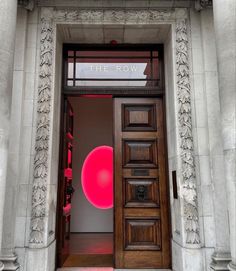 an entrance to a building with a large red object on the door