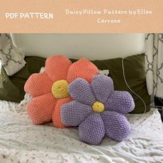 two knitted flowers on top of a bed with the caption daisy pillow pattern by ellen cerone