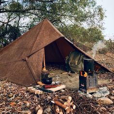 a brown tent sitting on top of a forest floor