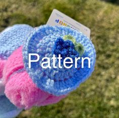 a crocheted blue and pink object with the word pattern on it's side