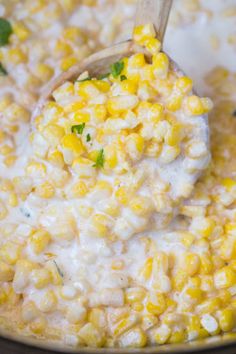 a spoon full of corn is being stirred in a pot