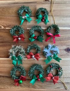 several christmas wreaths are arranged on a wooden surface