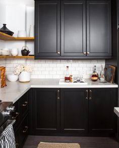 a kitchen with black cabinets and white counter tops