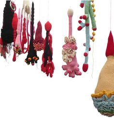 several knitted objects hanging from strings on a white background