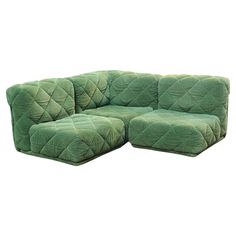 a large green couch sitting on top of a white floor