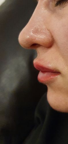 a close up of a woman's face with her nose open