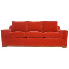 a red couch sitting on top of a white floor