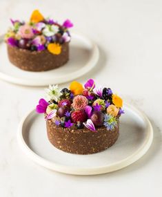 two white plates topped with cakes covered in flowers