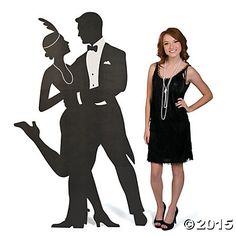 a woman standing next to a cut out of a man in a tuxedo