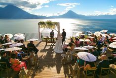 a bride and groom standing at the end of their wedding ceremony with umbrellas in front of them