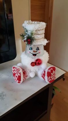 a stuffed snowman sitting on top of a table