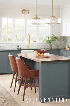 a kitchen with blue cabinets and an island in the middle, surrounded by wooden chairs