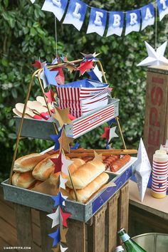 a table topped with sandwiches and buns next to a bottle of beer on top of a wooden crate