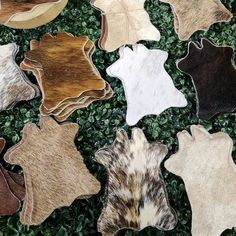 several cow hides laying on top of some green grass and plants in the background