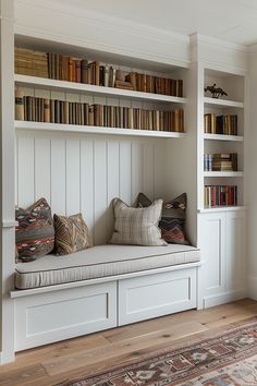 a room with bookshelves filled with lots of books next to a rug on the floor