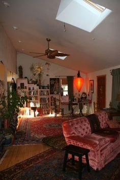 a living room filled with furniture and a ceiling fan in the middle of the room