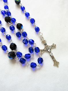 This Lutheran rosary is made with 6mm cobalt blue crystals. 8mm beads were used for the larger beads. The silver plated wires are hand turned. The rosary parts are silver plated pewter. The body of this rosary is about 20 inches around and the cross drop is about 4.5 inches. All of the silver plated wires are hand turned. This rosary will be slipped into a velvet bag and shipped in a bubble mailer. Blue Rosary With 8mm Beads And Crucifix, Blue Rosary With 8mm Beads In Cross Shape, Blue Rosary Bracelet For Jewelry Making, Handmade Blue Rosary With Cross Shape, Handmade Blue Rosary With Cross, Spiritual Blue Rosary With Round Beads, Blue Cross Jewelry With 8mm Beads, Blue Cross-shaped Jewelry With 8mm Beads, Blue Spiritual Rosary Bracelet With 8mm Beads