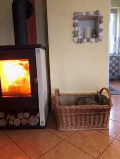 a basket sitting on the floor next to a wood stove