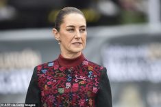 queen letizia of spain is wearing a red and black jacket with colorful flowers on it