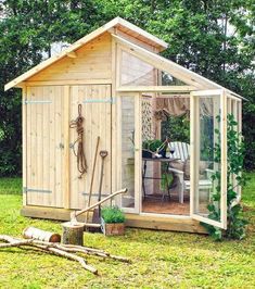 a small wooden shed sitting on top of a lush green field