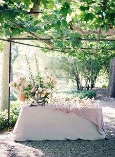 a table with flowers on it under a canopy