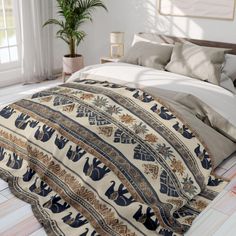 a bed covered in a blue and white comforter next to a potted plant