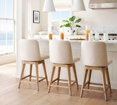 three chairs sitting in front of a kitchen counter