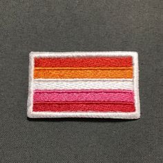 a patch with an orange, pink, and yellow stripe on it