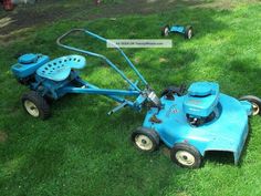 a blue lawn mower sitting in the grass