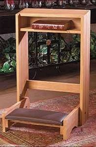 a wooden chair sitting under a table with a potted plant on it