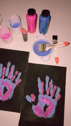 two handprints are shown on the table with paint and supplies to make them