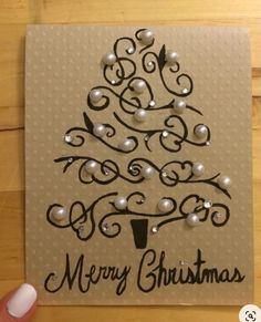 a handmade christmas card with a tree made out of pearls and black lettering on it