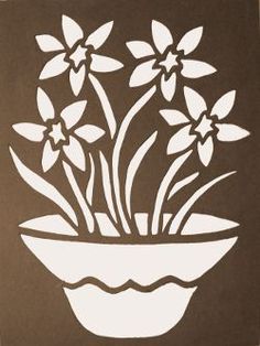 a white flower pot with flowers in it on a brown and white paper cutout