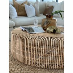 a wicker coffee table sitting on top of a rug