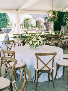 a table set up with chairs and flowers on it